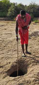 Amos, a Maasai guide, at a hole in a dry riverbed in Kenya